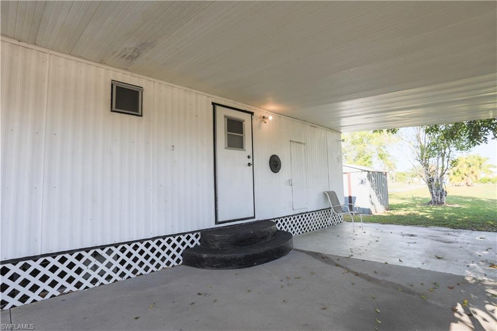 Property entrance featuring a patio and a lawn