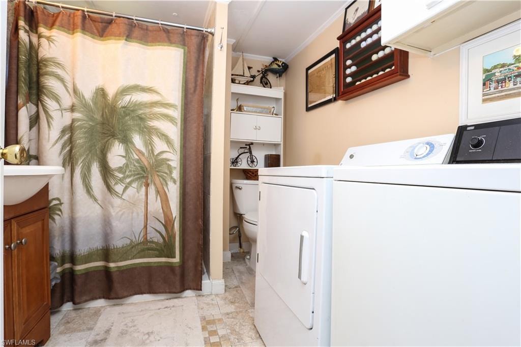 Laundry room with ornamental molding and washing machine and clothes dryer
