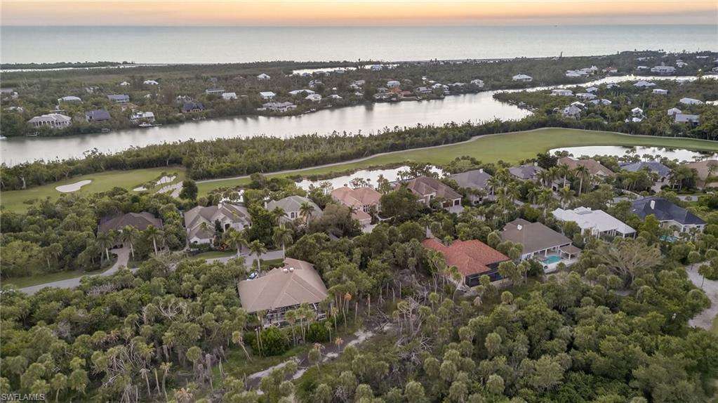 Aerial view of property and surrounding area with nearby suburban area, a large body of water, and a golf club