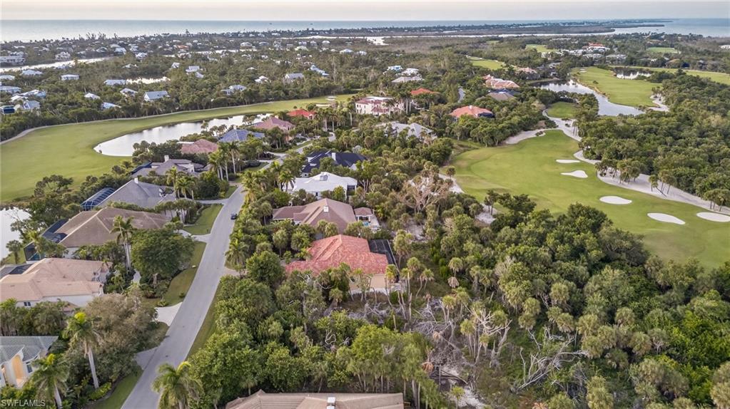 View of property location with a local golf course, a large body of water, and nearby suburban area