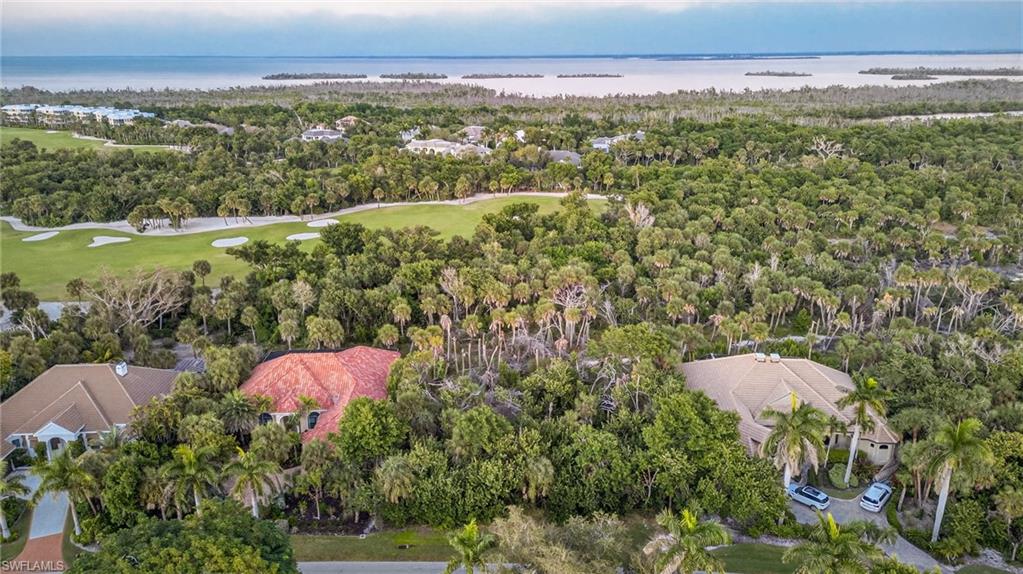 Aerial view of residential area featuring a nearby body of water and a local golf course