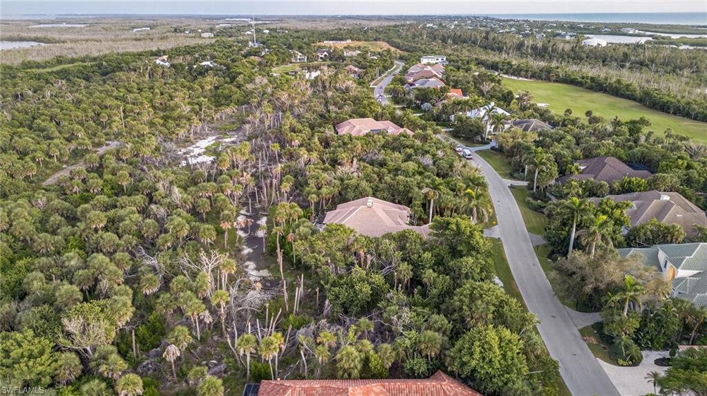 Aerial perspective of suburban area with a large body of water and a golf club