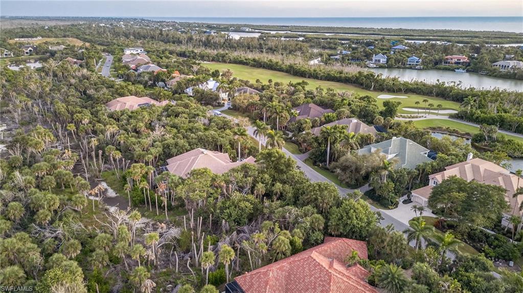 Aerial perspective of suburban area with a large body of water and a golf club