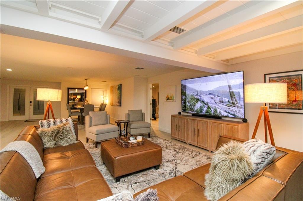 Tiled living room featuring beam ceiling