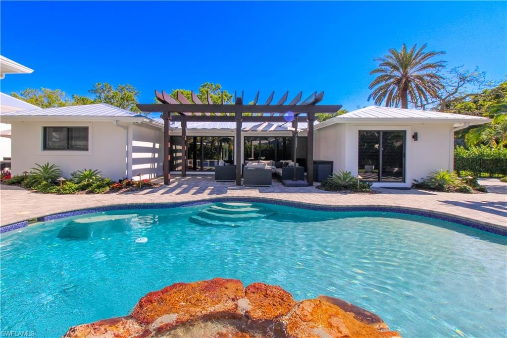 View of pool with a pergola, an outdoor living space, and a patio