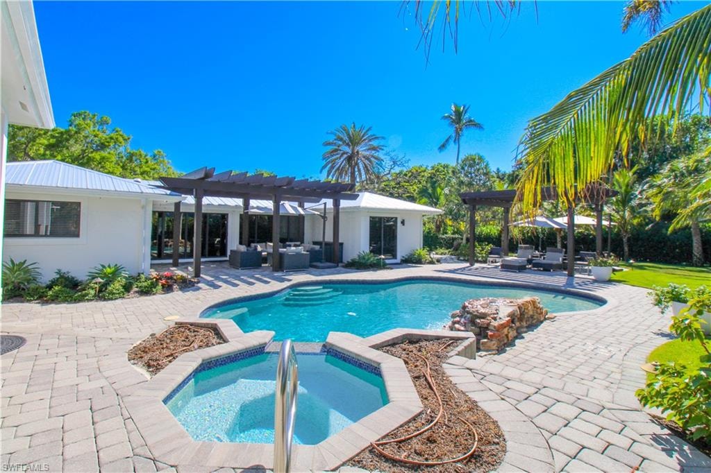 View of pool with an in ground hot tub, an outdoor living space, a pergola, and a patio