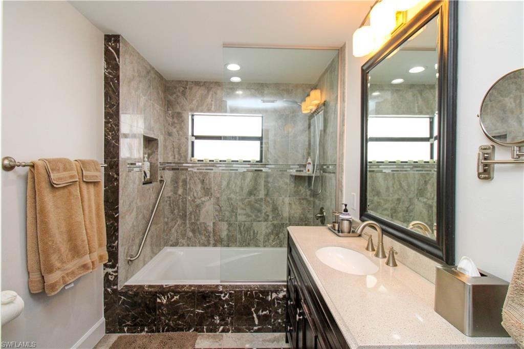 Bathroom with vanity and tiled shower / bath