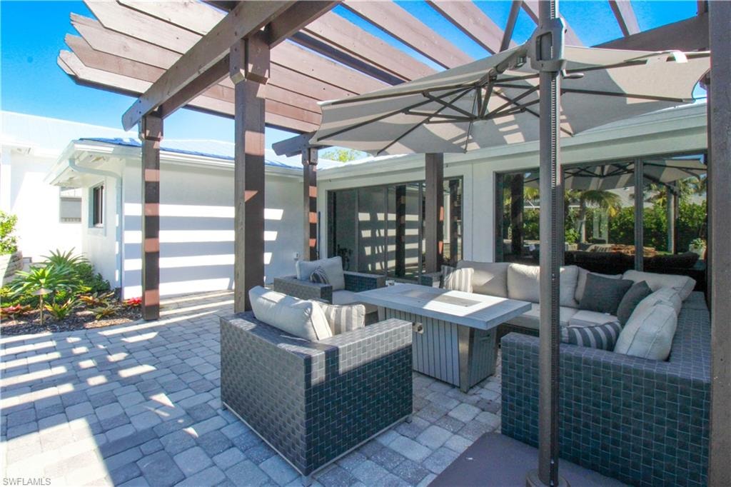 View of patio featuring a pergola and an outdoor living space with a fire pit