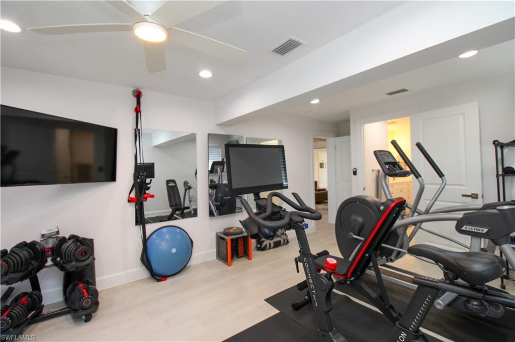 Exercise room featuring ceiling fan and light hardwood / wood-style flooring