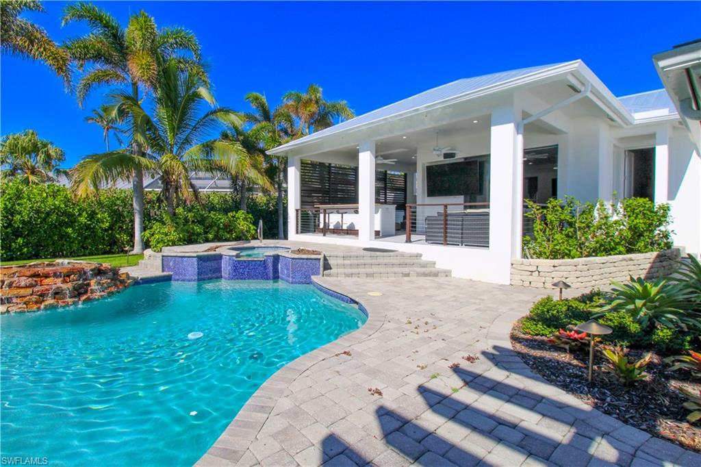View of pool featuring ceiling fan, a patio area, and an in ground hot tub