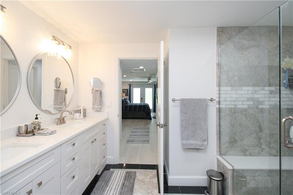 Bathroom with french doors, vanity, tile patterned floors, and a shower with door