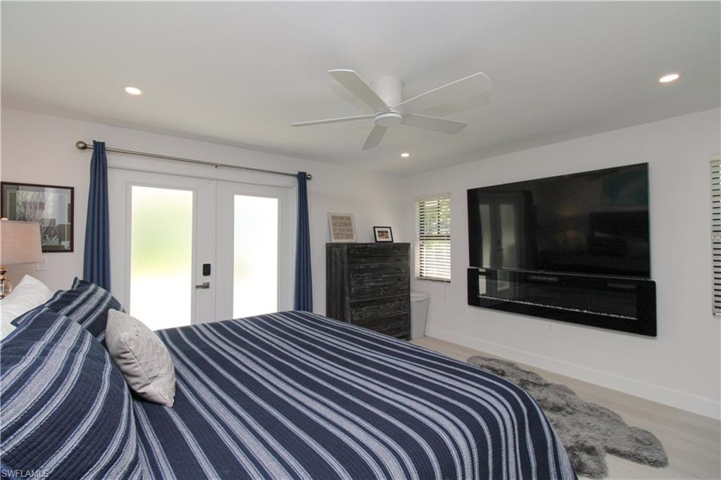 Bedroom featuring ceiling fan, light wood-type flooring, and french doors