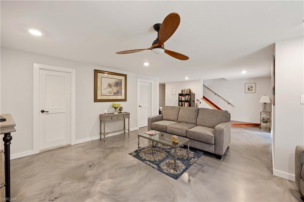 Living room featuring ceiling fan and concrete flooring