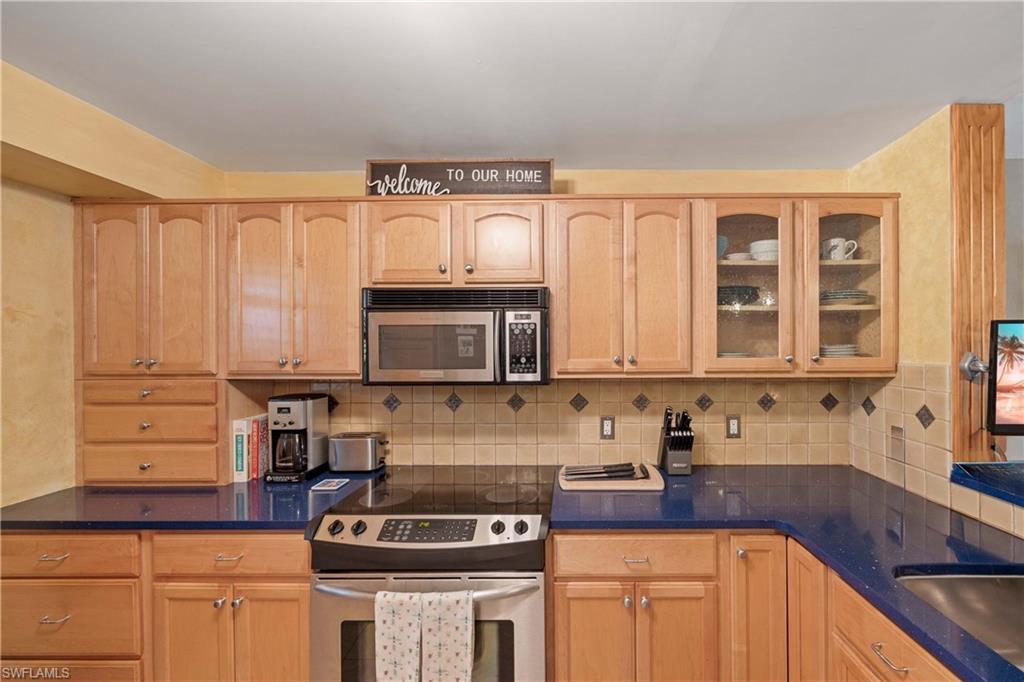 Kitchen with light brown cabinetry and stainless steel appliances