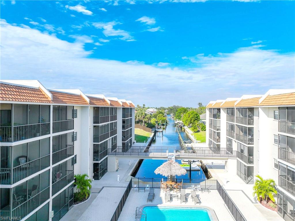 View of swimming pool with a water view and a patio