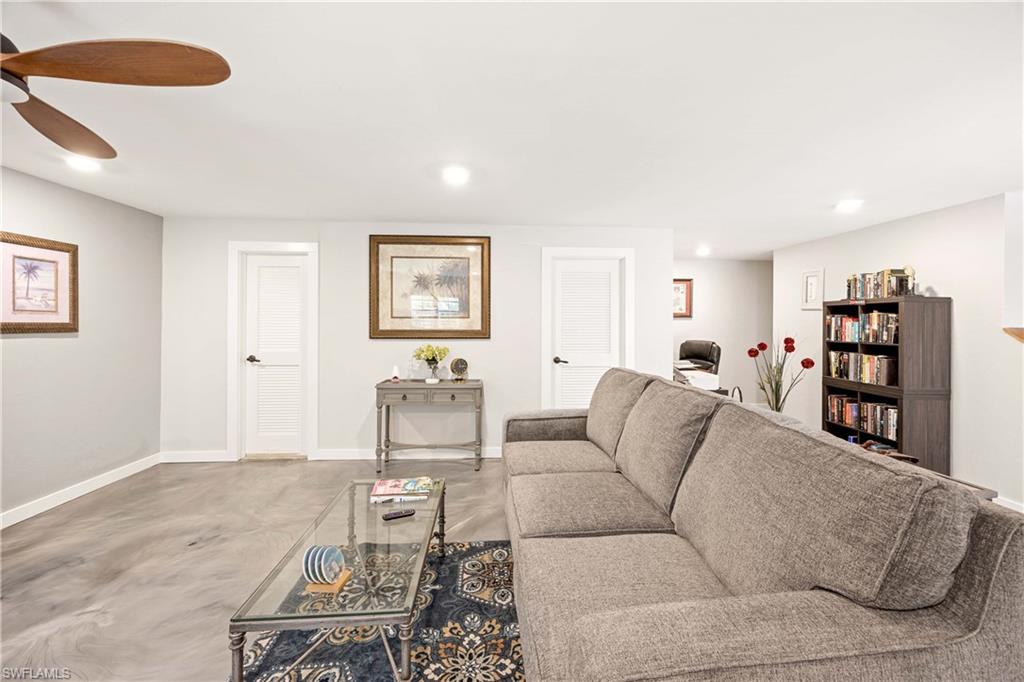 Living room featuring ceiling fan and concrete flooring
