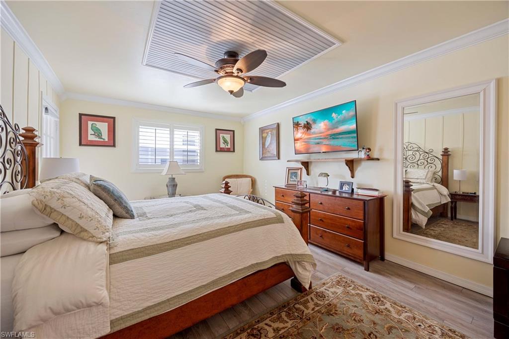 Bedroom with ceiling fan, light hardwood / wood-style floors, and ornamental molding