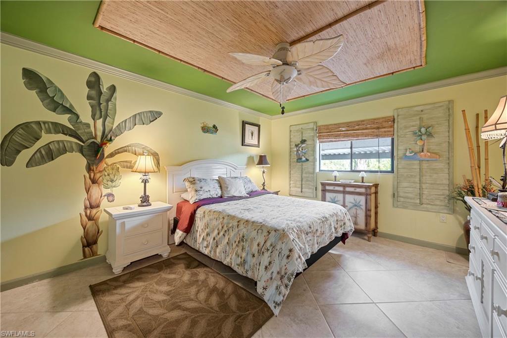 Bedroom featuring ceiling fan, crown molding, light tile patterned flooring, and wood ceiling