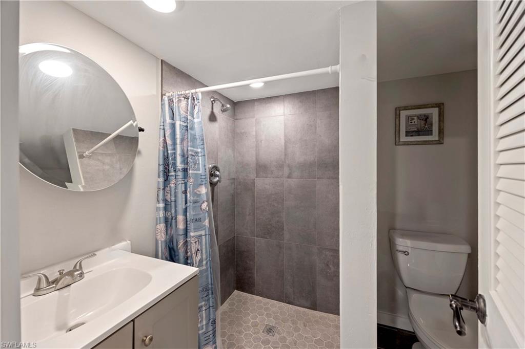 Bathroom featuring vanity, toilet, and walk in shower