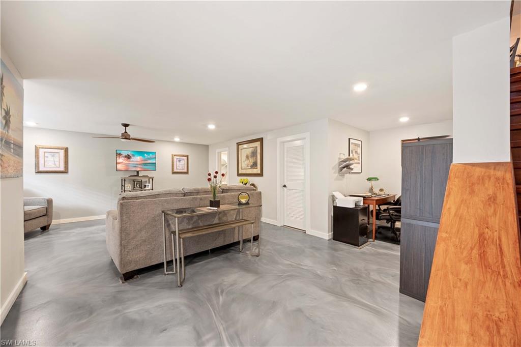 Living room with a barn door, concrete floors, and ceiling fan