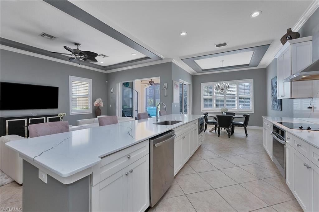 Kitchen with visible vents, a sink, stainless steel appliances, crown molding, and a raised ceiling