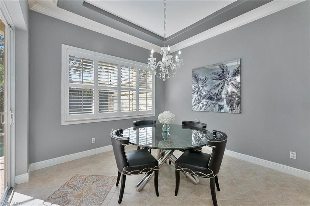 Tiled dining room with baseboards, a chandelier, and ornamental molding