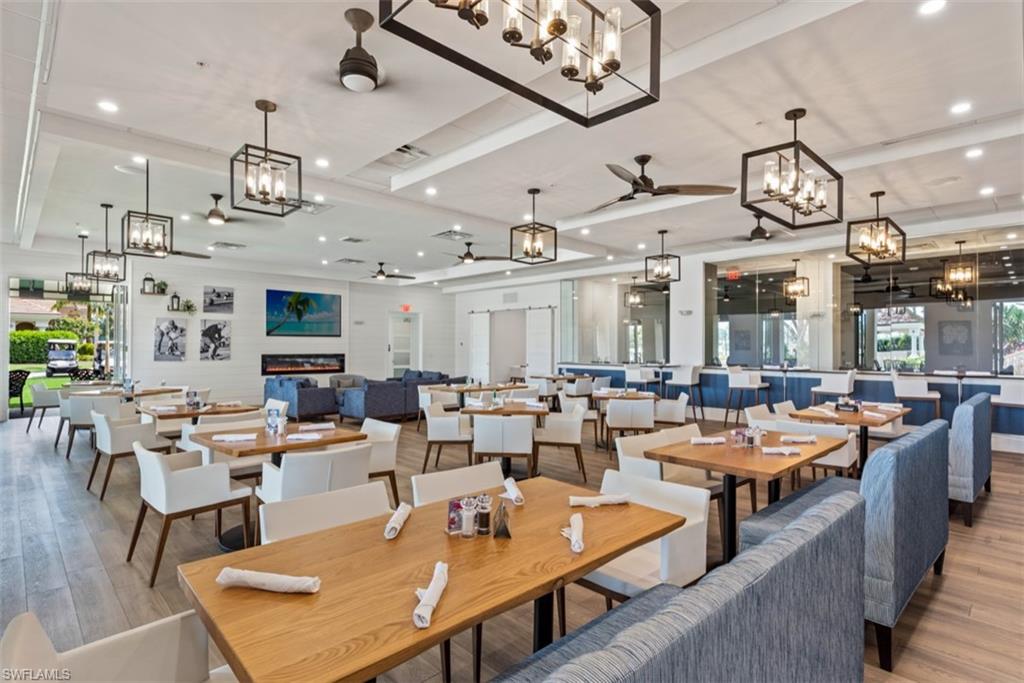 Dining area featuring wood finished floors, recessed lighting, ceiling fan with notable chandelier, and a raised ceiling