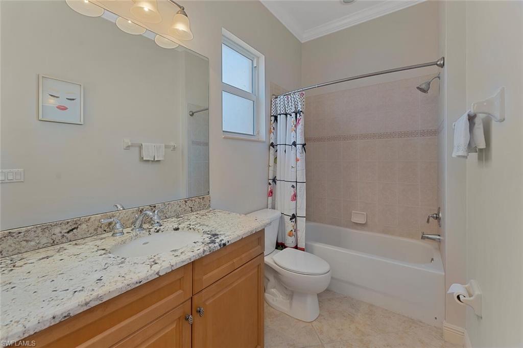 Full bath with crown molding, toilet, shower / bath combo, tile patterned floors, and vanity