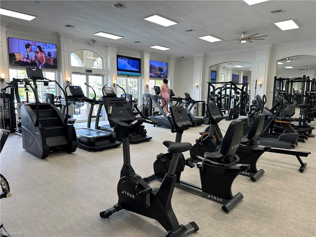 Exercise room featuring visible vents, ceiling fan, carpet flooring, and crown molding