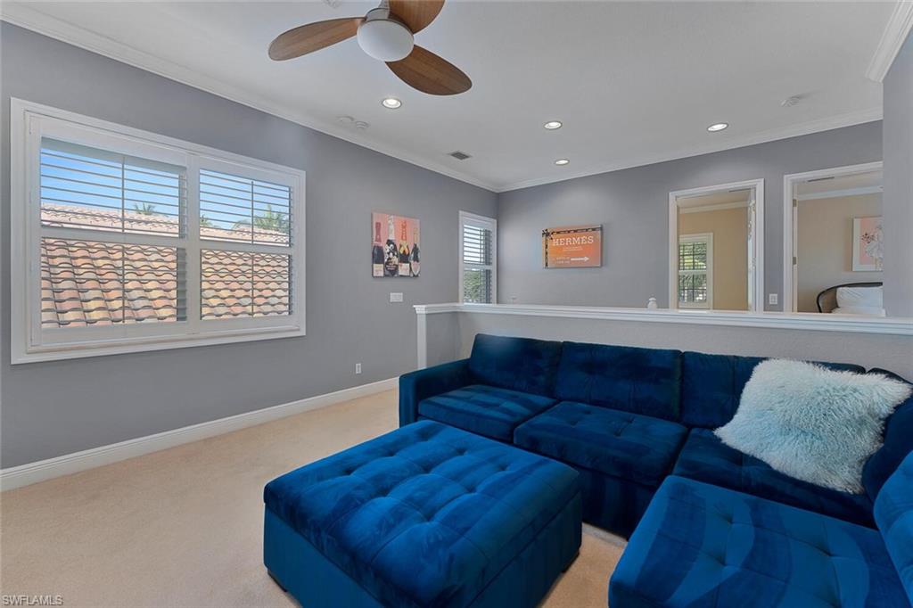 Living area with light carpet, recessed lighting, crown molding, baseboards, and ceiling fan