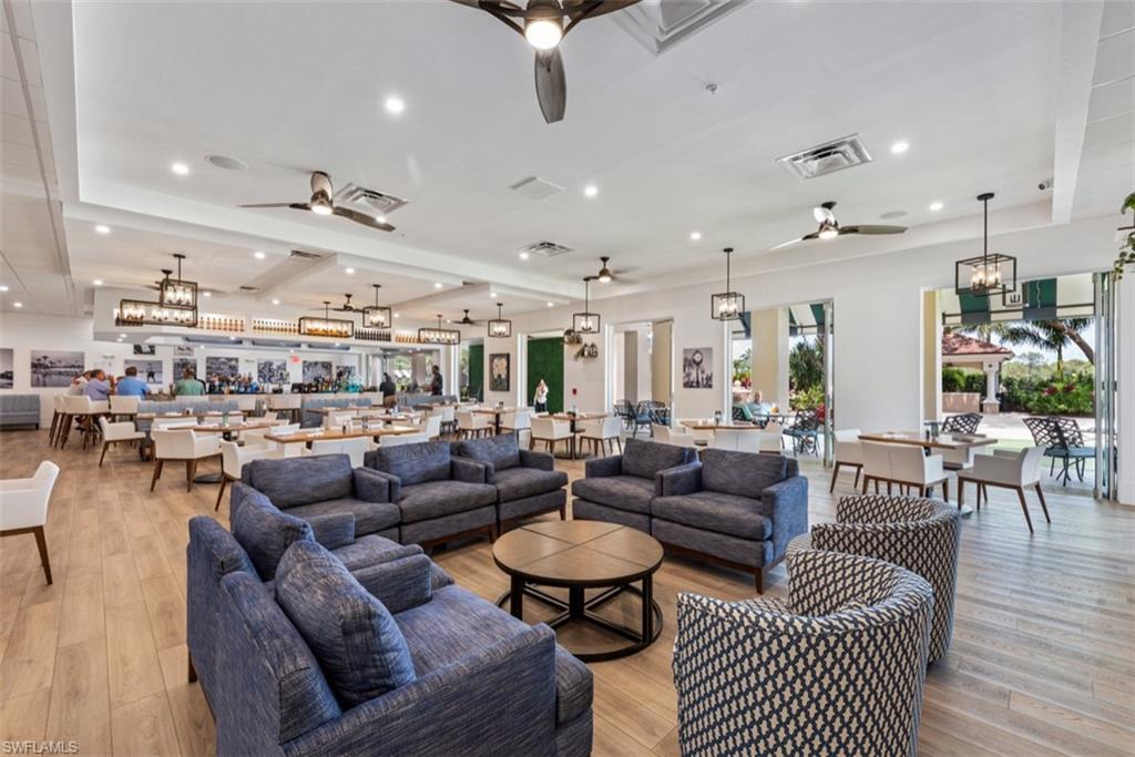 Living area with visible vents, ceiling fan with notable chandelier, and light wood-style flooring