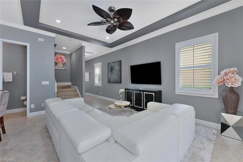Living room featuring ornamental molding, recessed lighting, light tile patterned floors, baseboards, and ceiling fan