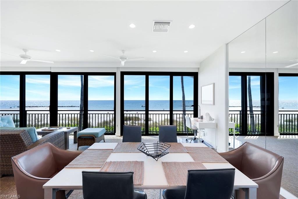 Dining area featuring a water view, recessed lighting, plenty of natural light, and carpet flooring