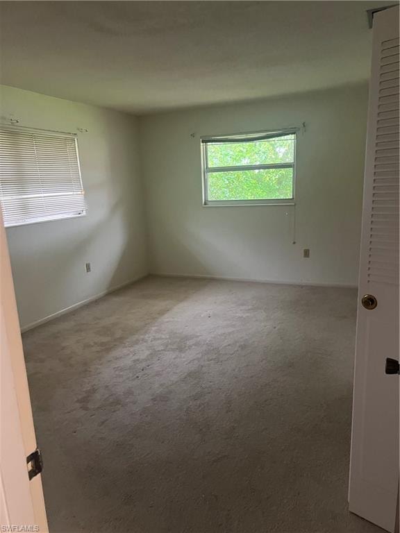 Unfurnished room featuring carpet floors and baseboards