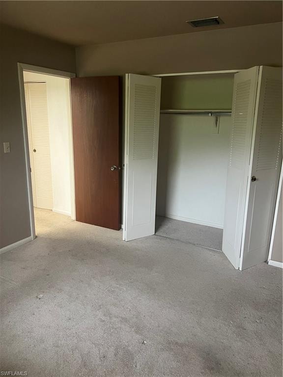 Unfurnished bedroom featuring a closet and light carpet