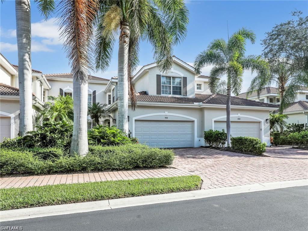 Mediterranean / spanish house with stucco siding, a tile roof, and decorative driveway