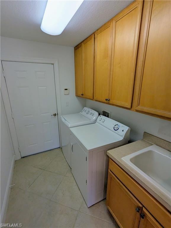 Laundry room with independent washer and dryer, cabinet space, and light tile patterned floors
