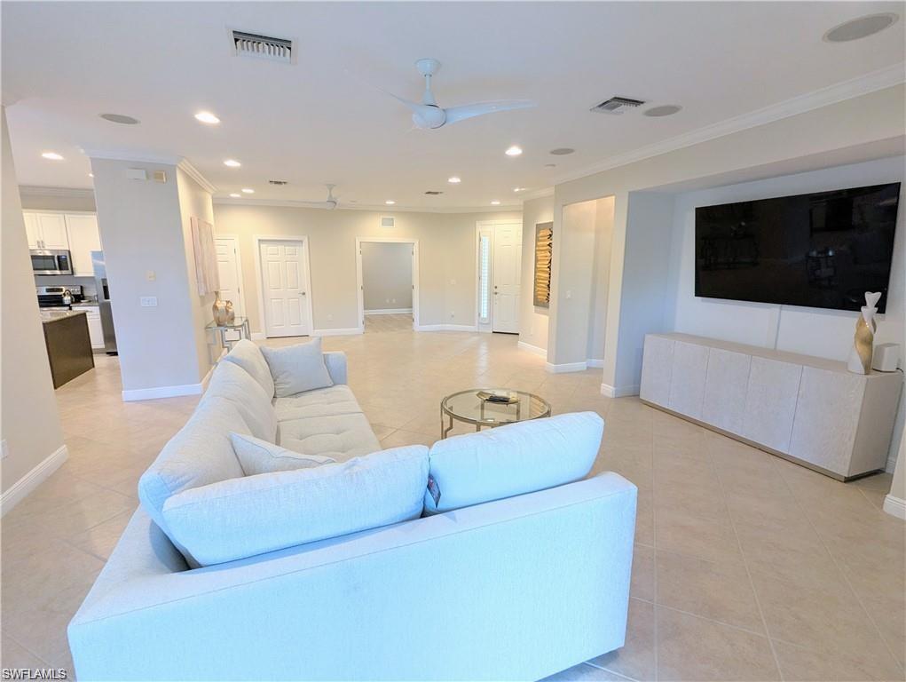 Living area with crown molding, recessed lighting, a ceiling fan, and light tile patterned floors