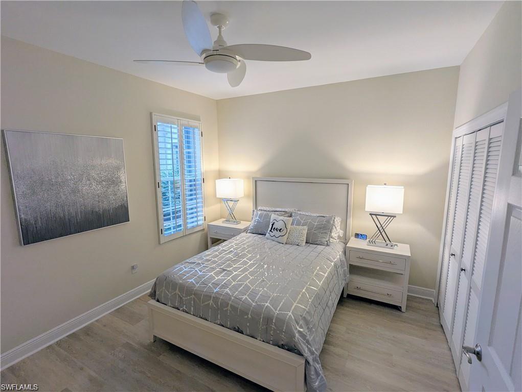 Bedroom with light wood-type flooring, ceiling fan, and a closet