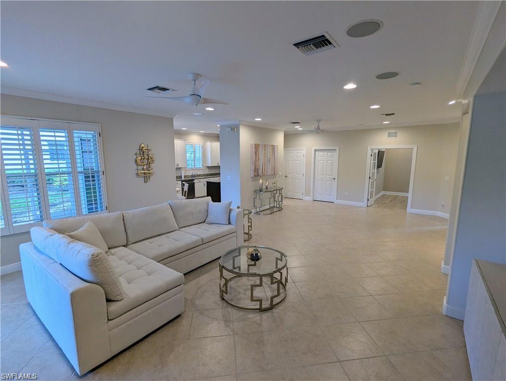 Living room featuring crown molding, recessed lighting, ceiling fan, and light tile patterned flooring