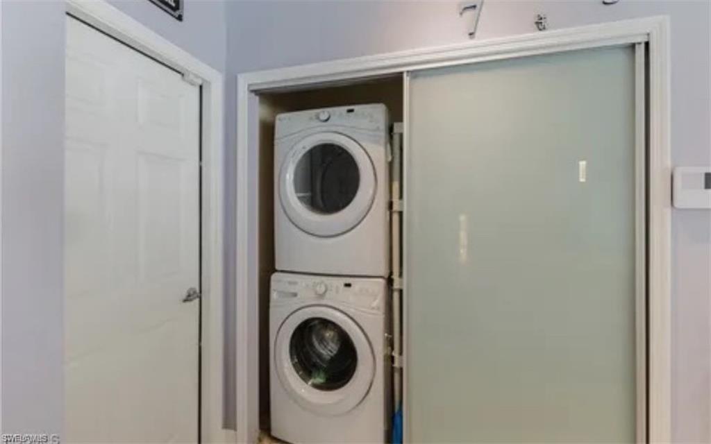 Laundry room with stacked washing machine and dryer