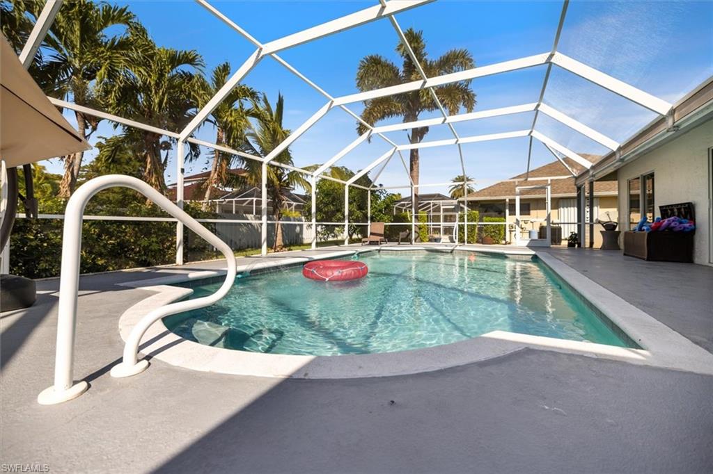 Swimming pool featuring a sunroom, glass enclosure, and a patio