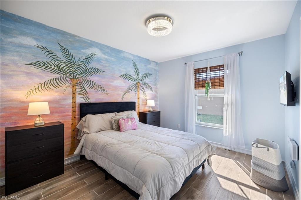 Bedroom with wood finished floors and an accent wall