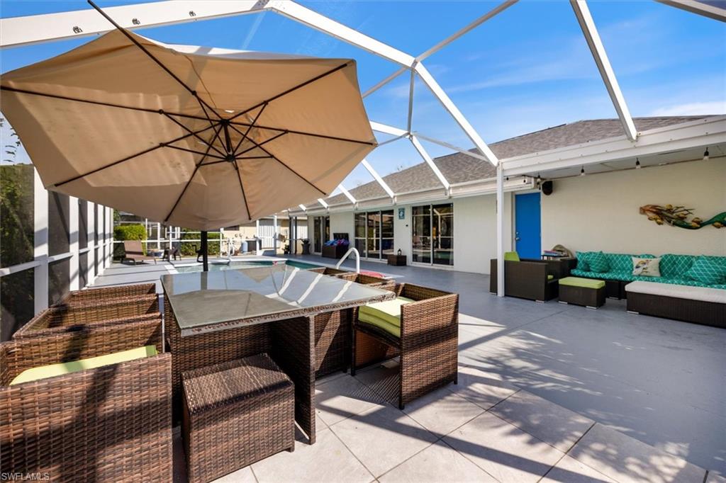 View of patio / terrace featuring a sunroom, a lanai, and an outdoor pool