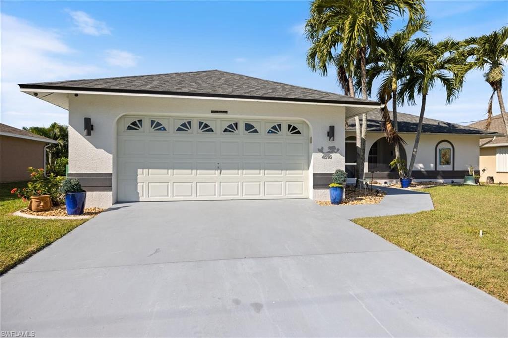 Single story home featuring a front yard, driveway, roof with shingles, stucco siding, and an attached garage
