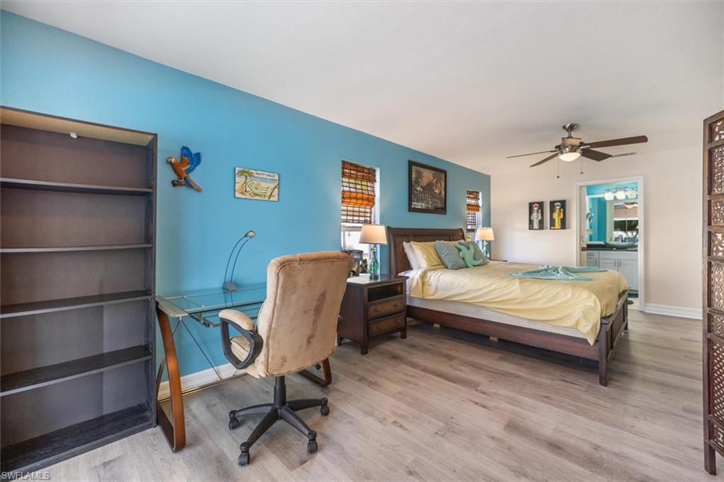 Bedroom with wood finished floors, ceiling fan, and ensuite bathroom