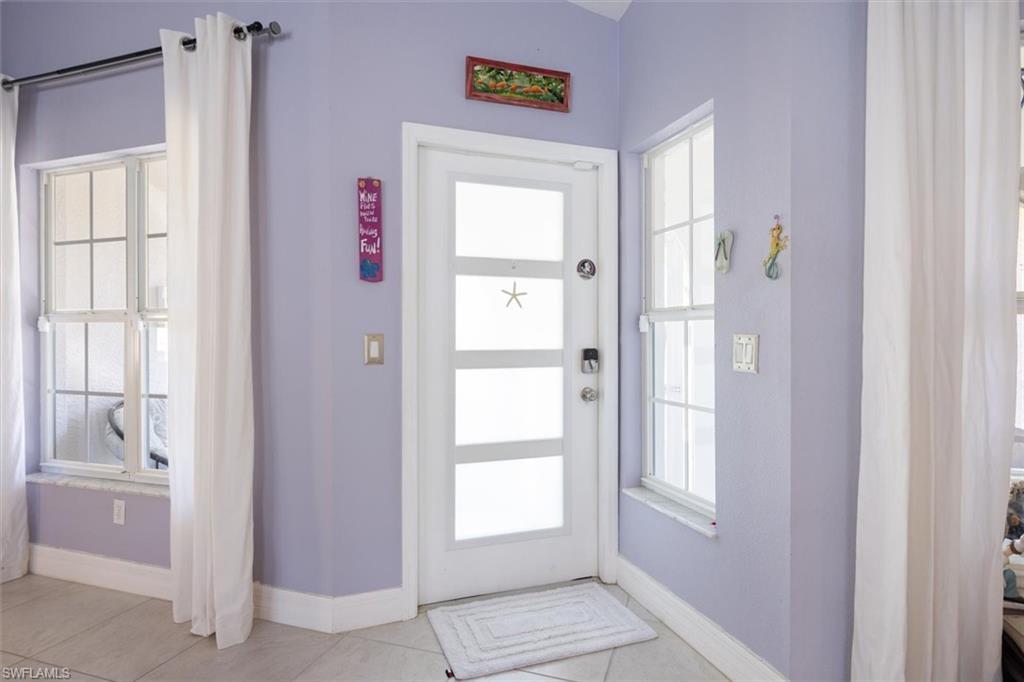 Doorway with tile patterned floors and baseboards