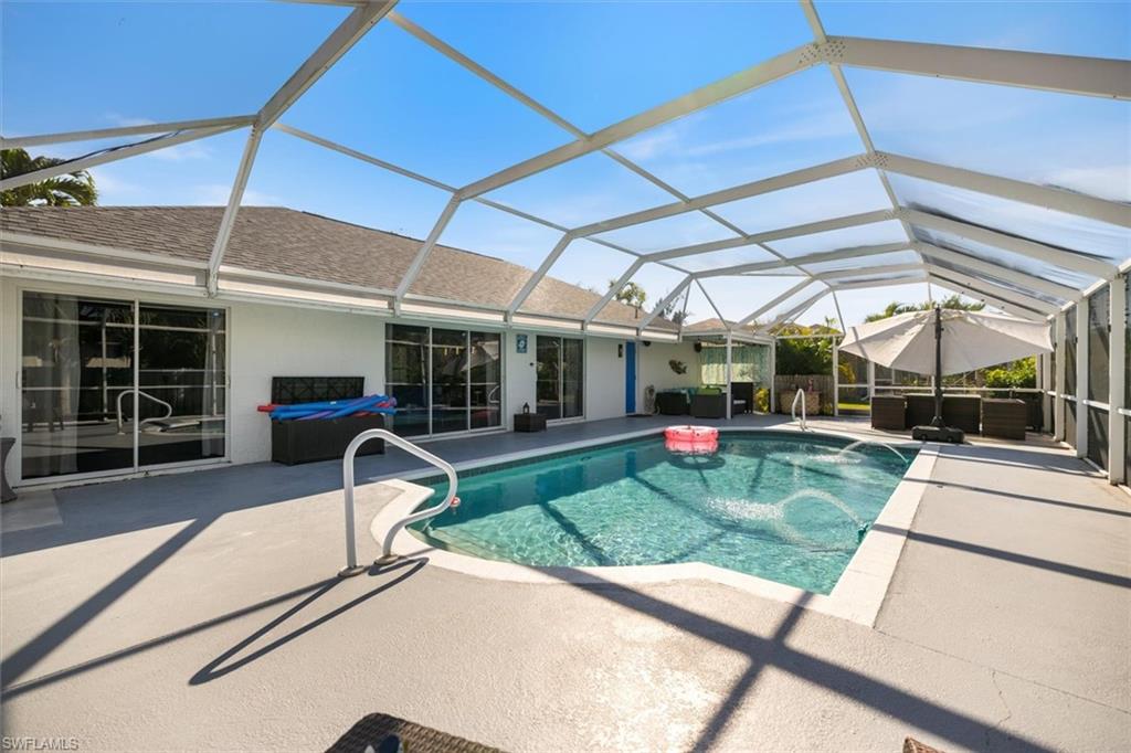 Outdoor pool featuring a sunroom, a lanai, a patio, and an outdoor living space