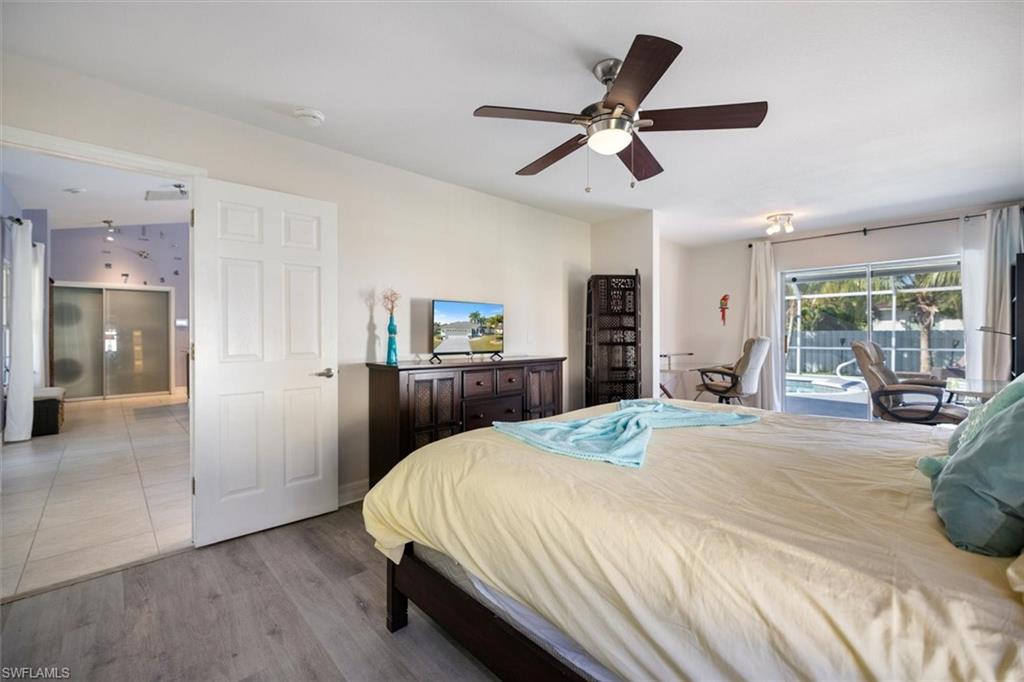 Bedroom with access to exterior, wood finished floors, and ceiling fan