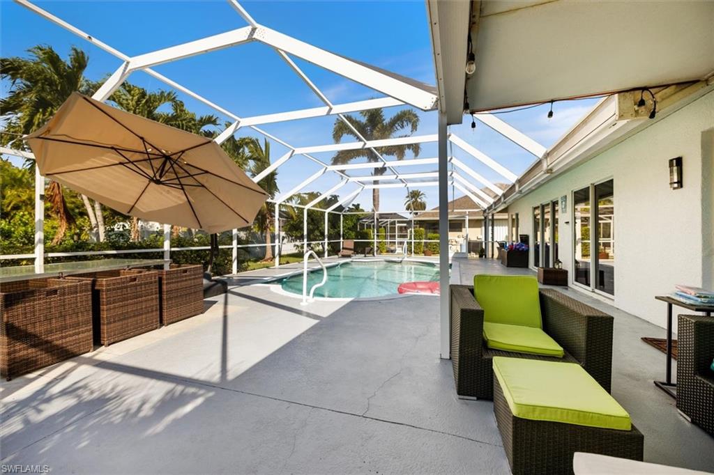 Outdoor pool with a patio, a sunroom, an outdoor living space, and a lanai